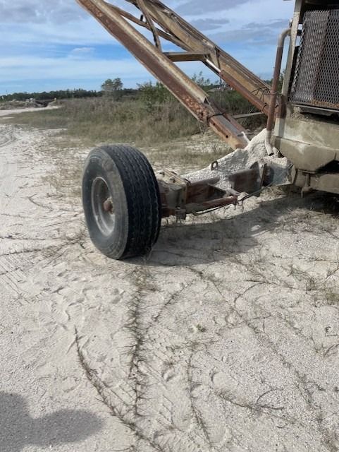 A truck is parked on the side of a dirt road.