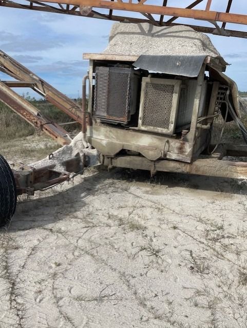 An old tractor is sitting in the dirt on the ground