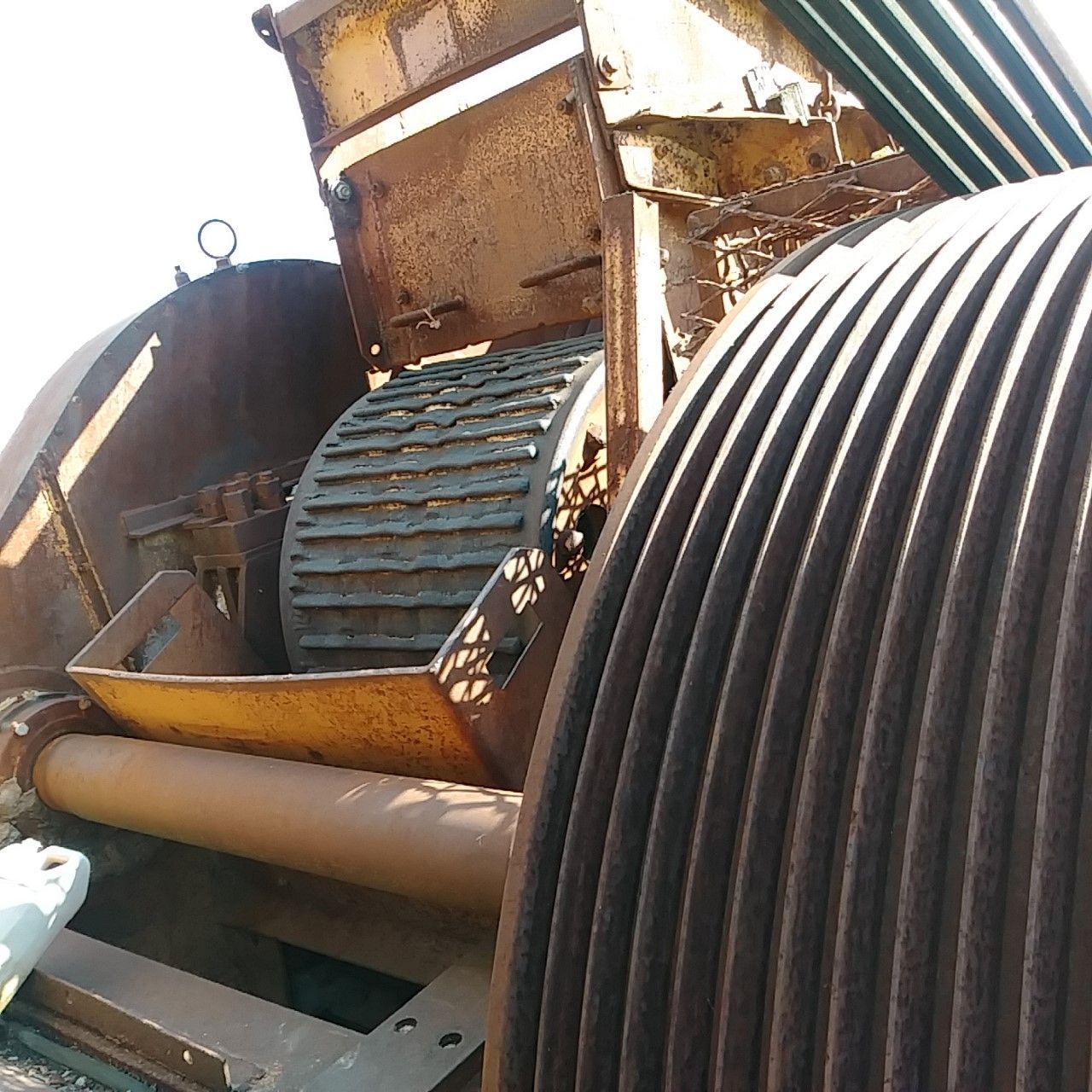 A close up of a rusty machine with a hose in the foreground