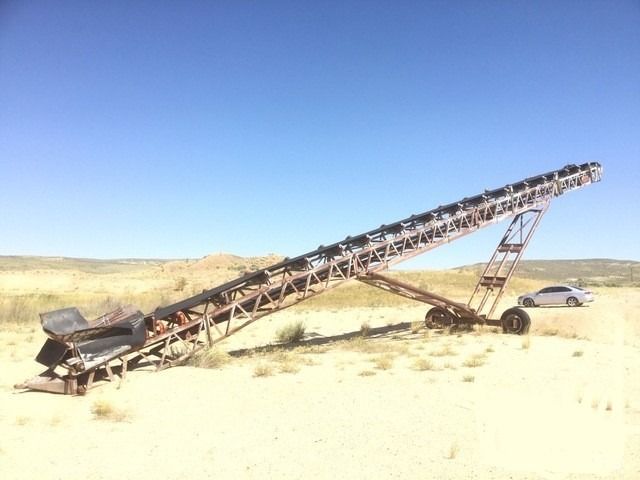 A conveyor belt is sitting in the middle of a desert.