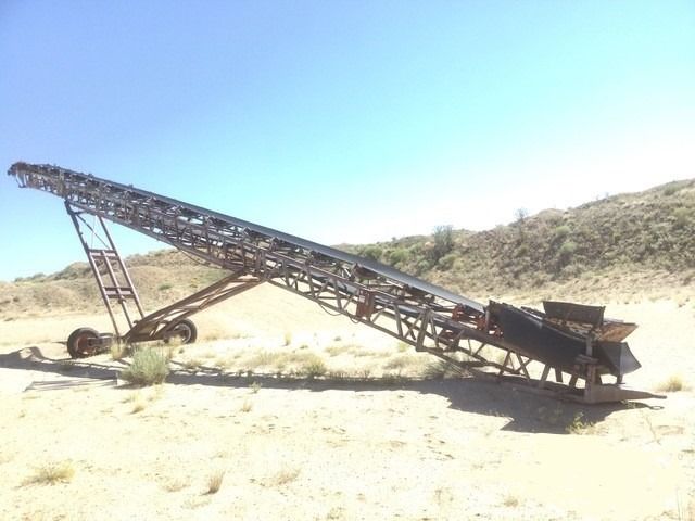 A conveyor belt is sitting in the middle of a desert.