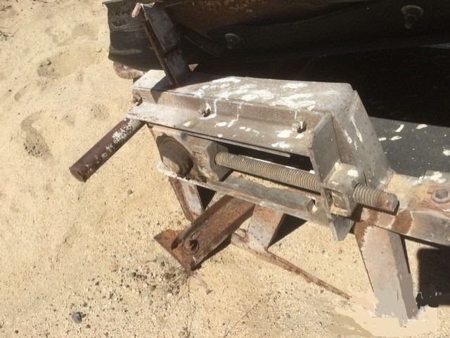 A piece of metal is sitting on a sandy surface.