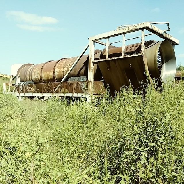 A large pipe is sitting in the middle of a grassy field
