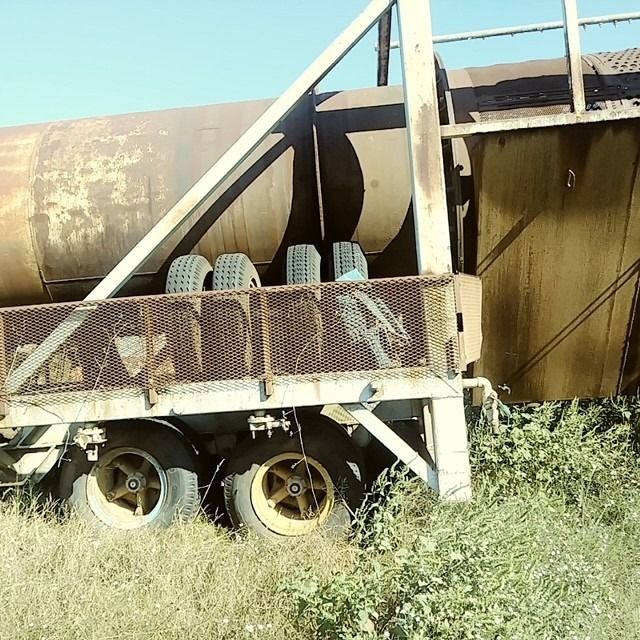 A truck with a fence behind it that says ' a ' on it
