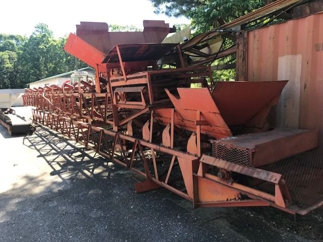 A row of rusty machinery sits in front of a building