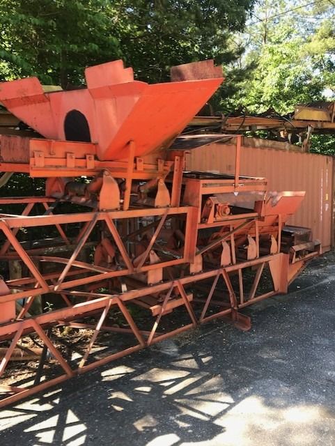 A large orange machine is parked on the side of the road