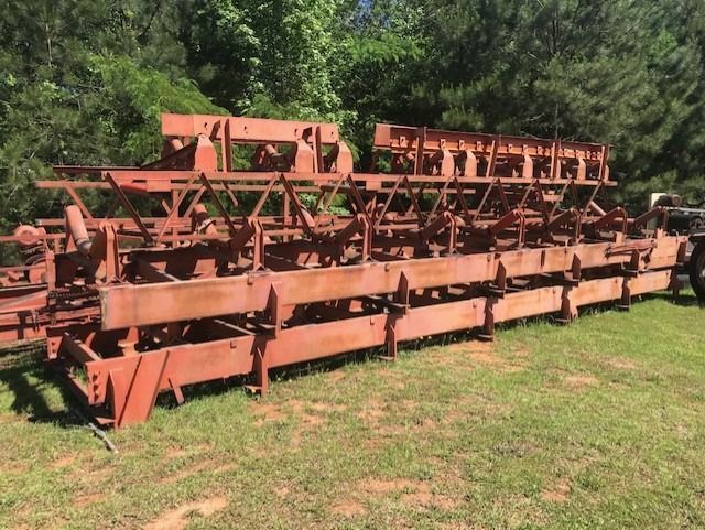 A large wooden structure is sitting on top of a lush green field.