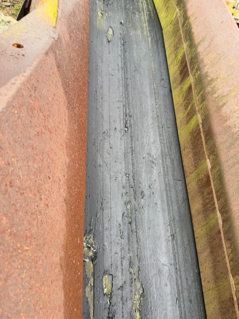 A close up of a metal pipe on a concrete surface.