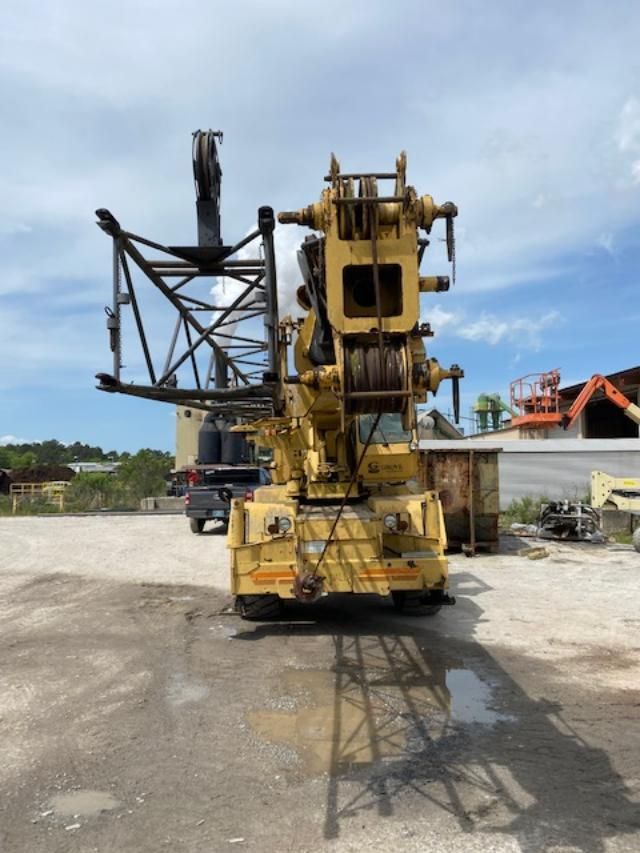 A large yellow crane is parked in a parking lot