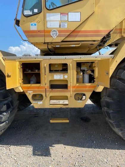 A yellow truck with the doors open and a ladder