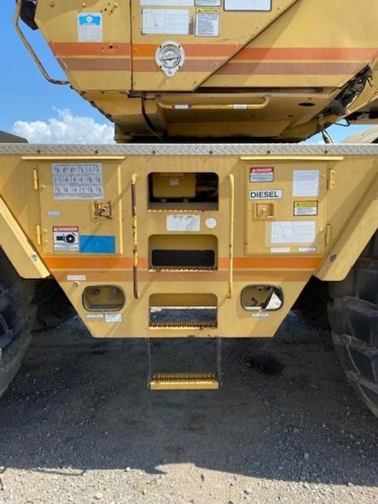 A yellow truck with a ladder on the back of it
