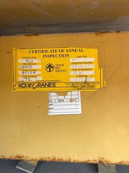 A yellow sign that says certificate of annual inspection on it