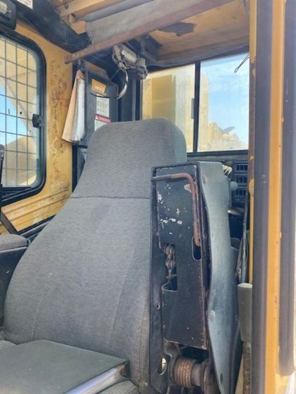 A gray seat in a yellow vehicle with a window