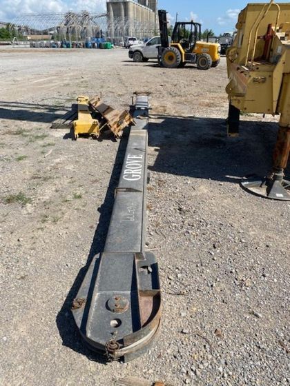 A yellow forklift is parked in a gravel lot