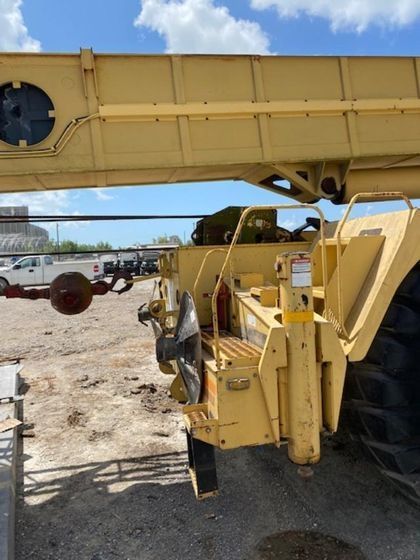 A yellow crane is parked in a parking lot