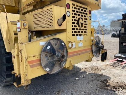 A yellow tractor is parked on the side of the road.