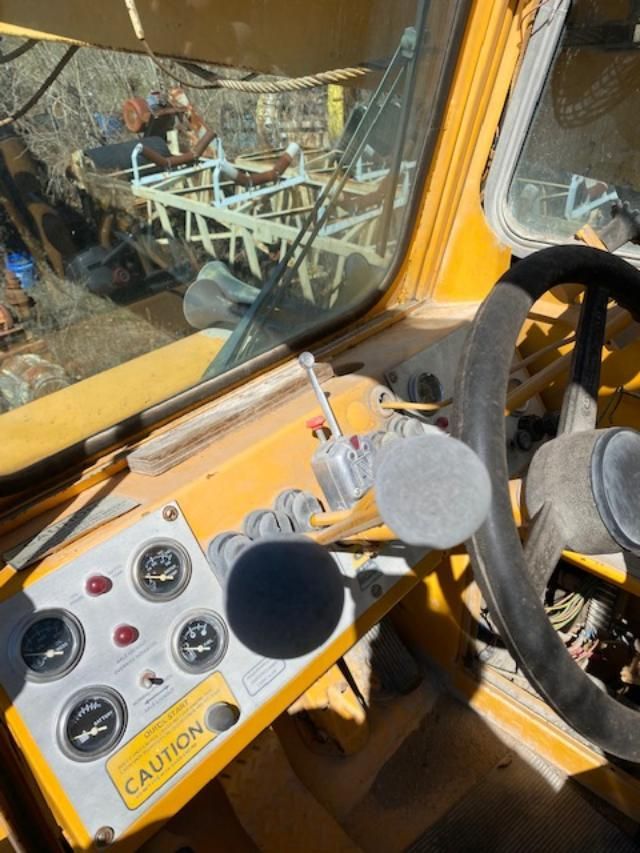 The inside of a yellow truck with a caution sign on the dashboard.