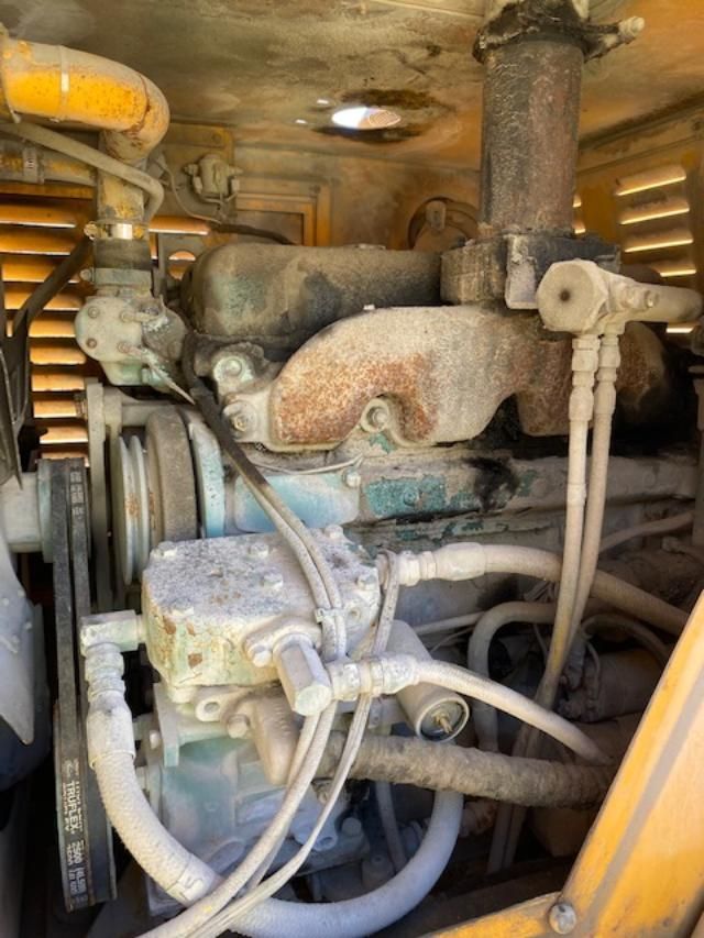 A close up of a dirty engine with a lot of hose attached to it.