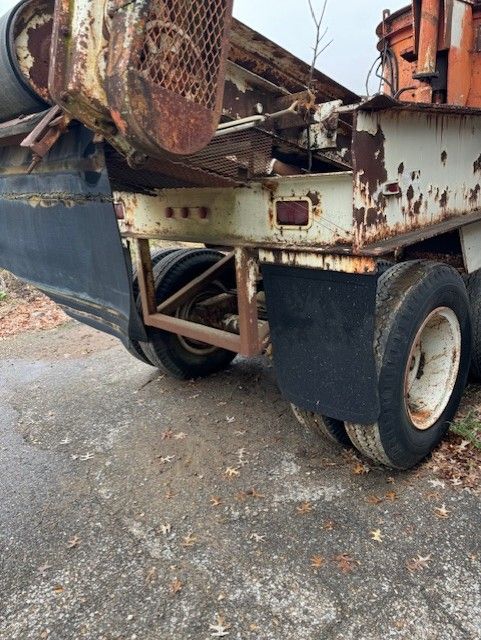 An old rusty truck is parked on the side of the road