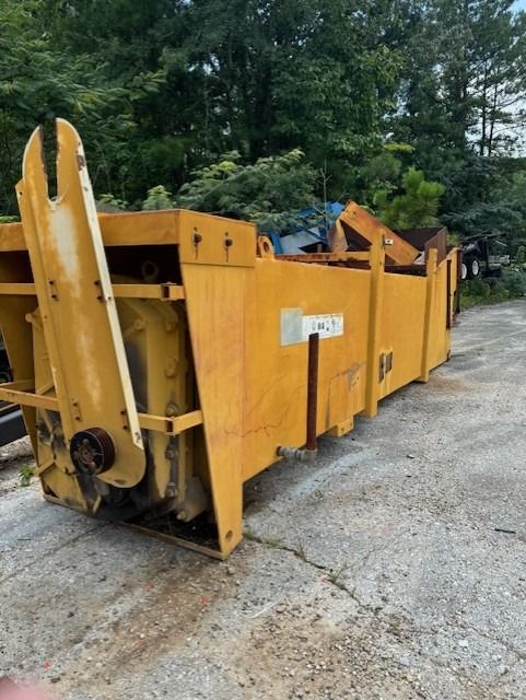 A large yellow dumpster is sitting on the side of the road