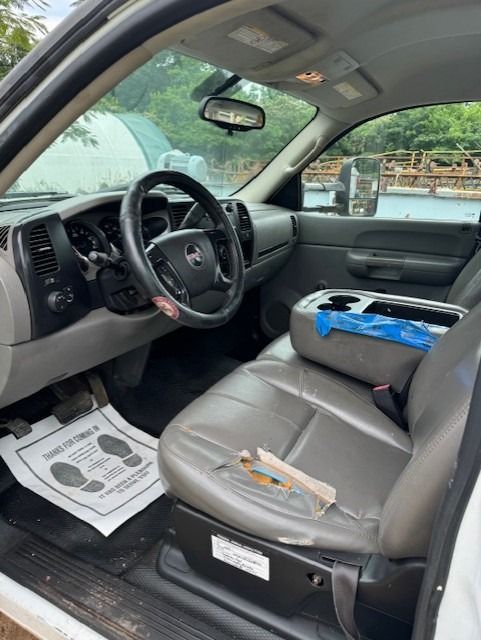 The inside of a white truck with a steering wheel and seats