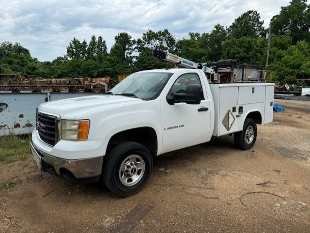 A white utility truck is parked on the side of the road.
