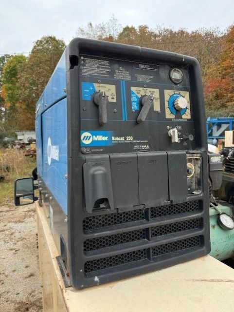 A welding machine is sitting on top of a wooden table.