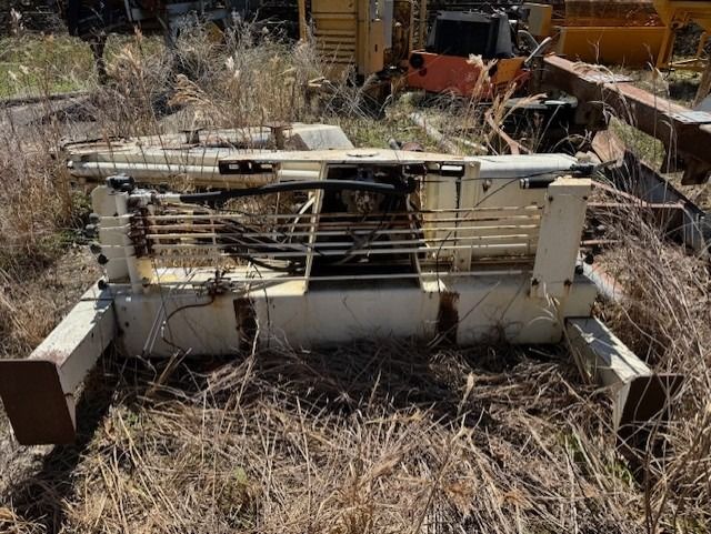 A machine is sitting in the middle of a field of dry grass.