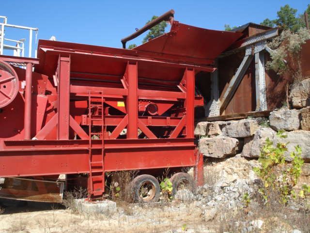 A large red machine is parked in a field