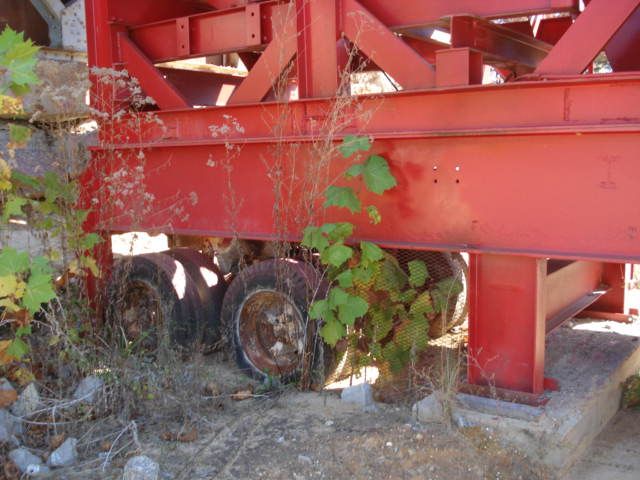 A red metal structure with a plant growing out of it