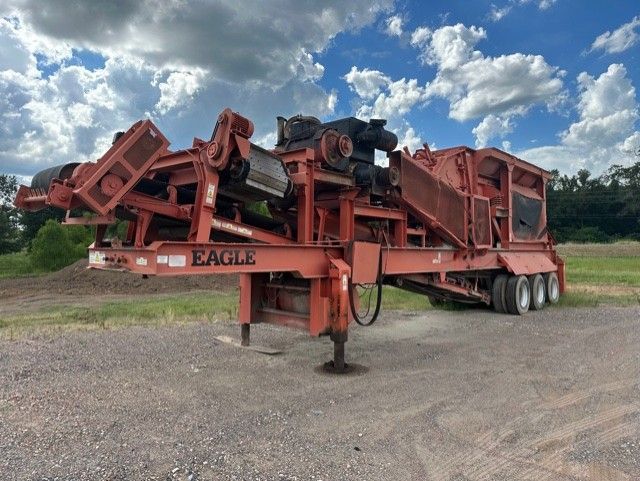 A large red machine is parked on the side of the road.