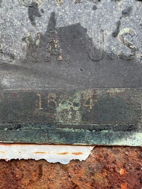 A close up of a rusty piece of metal with a number on it.