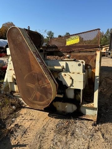 A large machine is sitting on top of a dirt field.