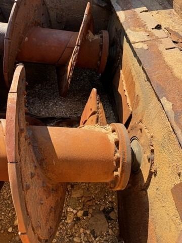 A close up of a rusty metal object on a rocky surface.