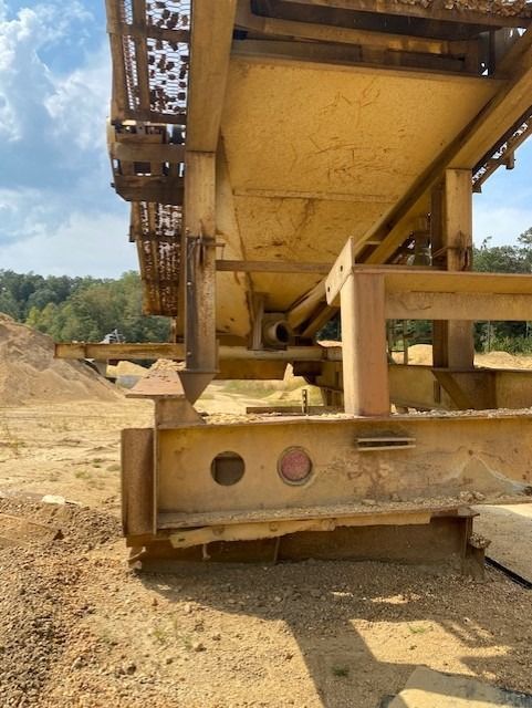 A large metal structure is sitting in the middle of a dirt field