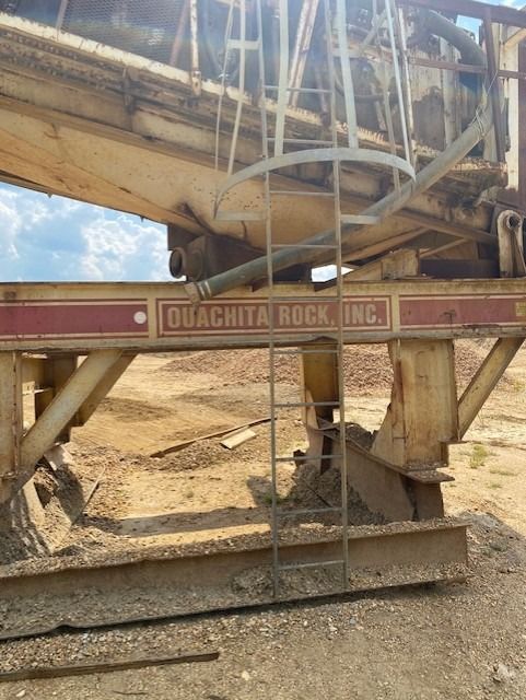 A ladder is attached to the side of a quachita rock ing machine