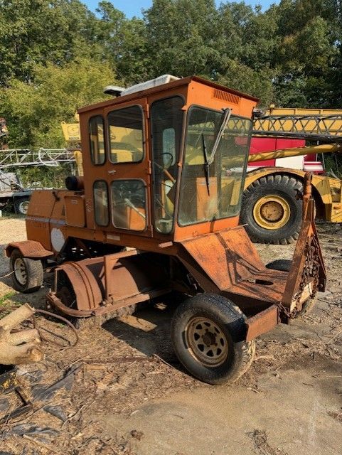 An old rusty tractor is sitting in the dirt.