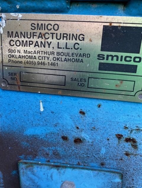 A smco manufacturing company sign on a blue surface
