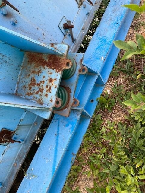 A blue metal beam with a green spring attached to it