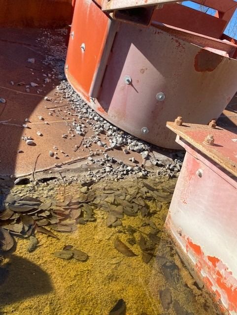 A pile of rocks is sitting on the ground next to a red object