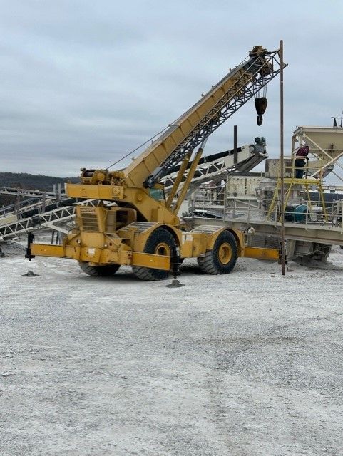 A yellow crane is parked in a snowy field