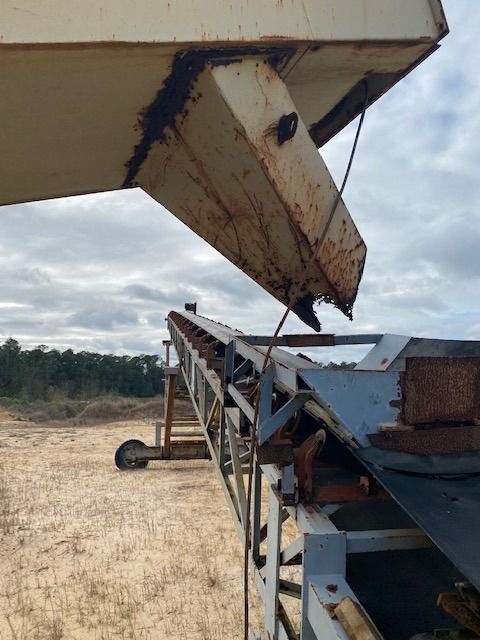A conveyor belt is being used in a field