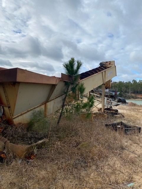 A large metal structure is sitting in the middle of a field.