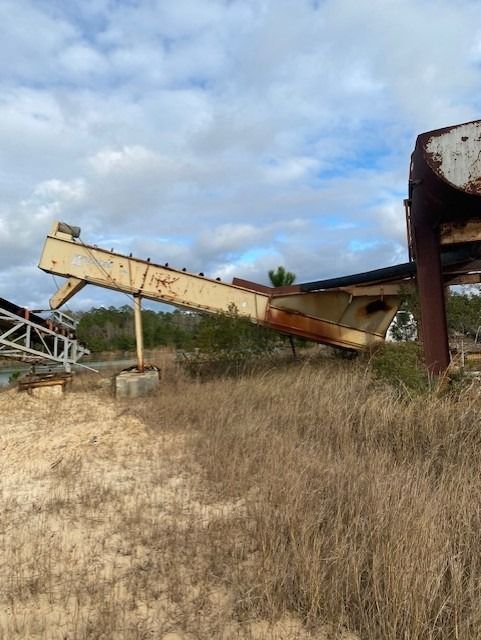 A large metal structure is sitting in the middle of a field.