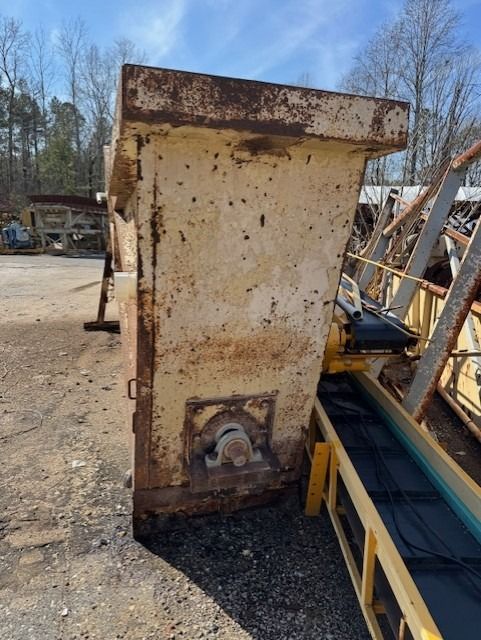 A conveyor belt is attached to a large metal structure