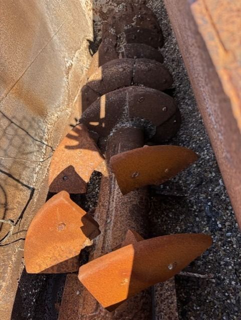 A close up of a rusty pipe with a few pieces of wood on it
