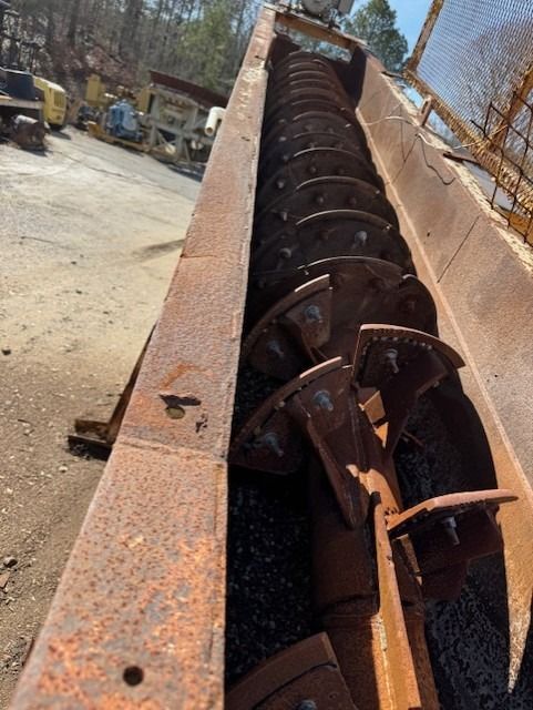 A large rusty machine is sitting on the ground in a parking lot.