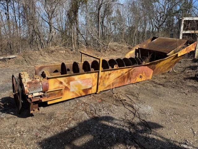 A large piece of metal is sitting on the ground in a field.