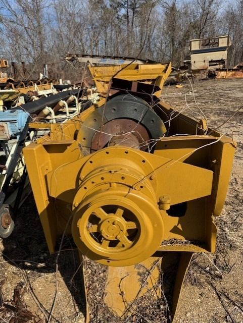 A large yellow machine is sitting in the dirt
