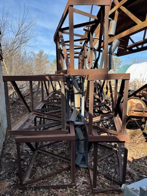 A wooden structure is sitting in the middle of a field